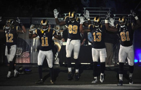 Members of the St. Louis Rams raise their arms as they walk onto the field during introductions before an NFL football game against the Oakland Raiders, Sunday, Nov. 30, 2014, in St. Louis. (Image source: AP/L.G. Patterson)